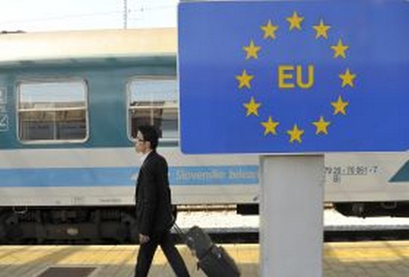 A passenger walks past a European Union sign at the border cross with Croatia in Dobova