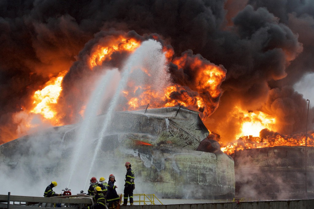 (150407) -- GULEI, April 7, 2015 (Xinhua) -- Firefighters try to extinguish fire at the site of a chemical plant blast in Zhangzhou, southeast China's Fujian Province, April 7, 2015. A xylene facility leaked oil and caught fire, which led to blasts and a fire at three nearby oil storage tanks at Tenglong Aromatic Hydrocarbon (Zhangzhou) Co. Ltd. on the Gulei Peninsula in Zhangzhou City at 6:56 p.m. (1056GMT) on Monday. Six people were injured in the plant blast. (Xinhua/Jiang Kehong) (lfj)