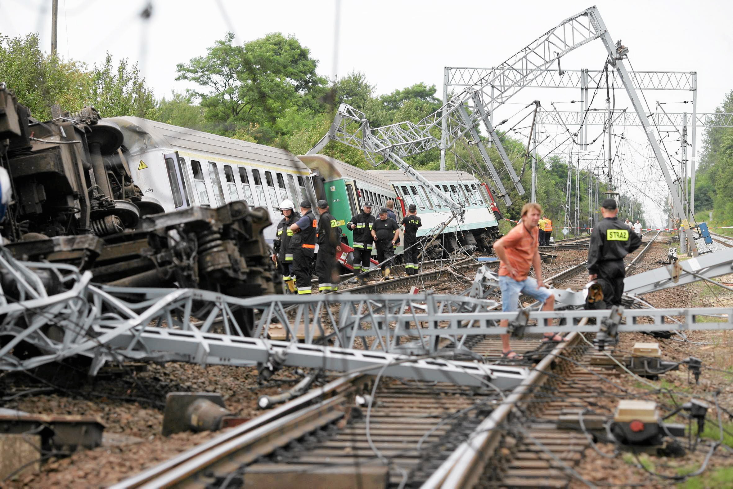 Emergency services personnel inspect the wreckage of a passenger train that derailed near the village of Baby