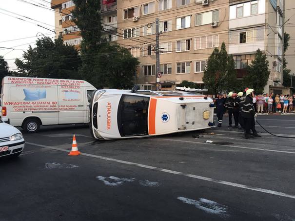 [FOTO] O ambulanţă s-a răsturnat după ce a fost lovită de un autoturism. Cinci persoane, la spital