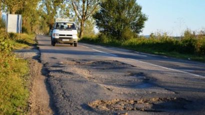 Plin de gropi, denivelări şi crăpături. Un drum din Banat este în lucru de peste patru decenii!