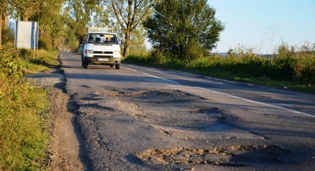 Plin de gropi, denivelări şi crăpături. Un drum din Banat este în lucru de peste patru decenii!